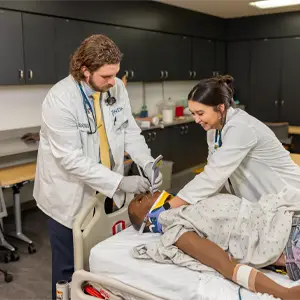 Two students working on a patient simulator