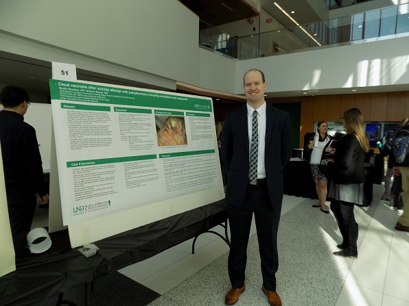 resident presenting research poster at symposium